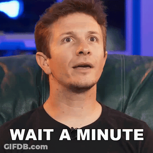 A Man Is Sitting In A Chair With The Words Wait A Minute Written On The Bottom GIF
