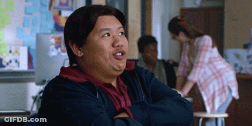 A Man Is Sitting In A Classroom With His Arms Crossed And His Mouth Open GIF