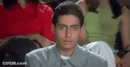 A Man Is Sitting In A Crowd Of People Watching A Movie And Making A Funny Face . GIF