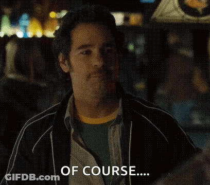 A Man Is Sitting In A Dark Room With His Eyes Closed And Making A Funny Face . GIF