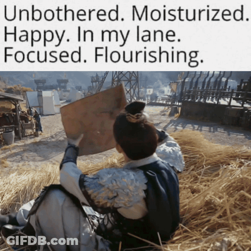 A Man Is Sitting In A Field Holding A Piece Of Paper With The Caption Unbothered Moisturized GIF