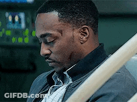 A Man Is Sitting In A Hospital Bed With His Eyes Closed And A Scar On His Face . GIF