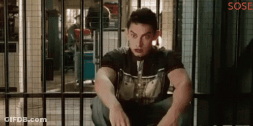 A Man Is Sitting In A Jail Cell With The Word Sose On The Bottom Right GIF
