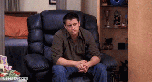 A Man Is Sitting In A Leather Chair With His Hands Folded GIF