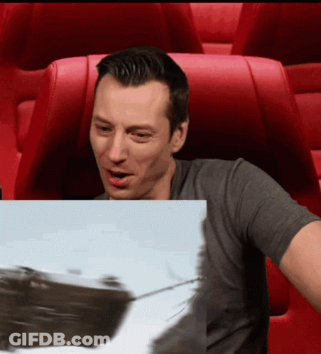 A Man Is Sitting In A Red Chair Looking At A Picture Of A Boat GIF