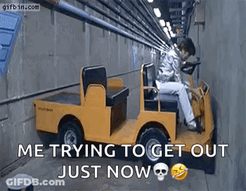 A Man Is Sitting In A Small Yellow Car In A Tunnel . GIF