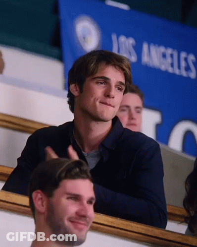 A Man Is Sitting In A Stadium In Front Of A Los Angeles Banner GIF