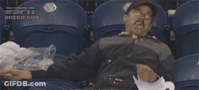 A Man Is Sitting In A Stadium With His Face Covered In Food And A Bag Of Trash . GIF