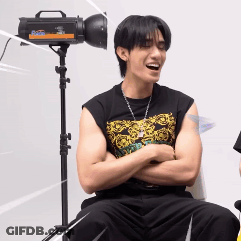 A Man Is Sitting In Front Of A Camera That Says Flash GIF