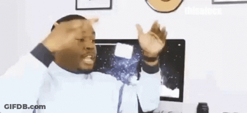 A Man Is Sitting In Front Of A Computer Making A Funny Face . GIF