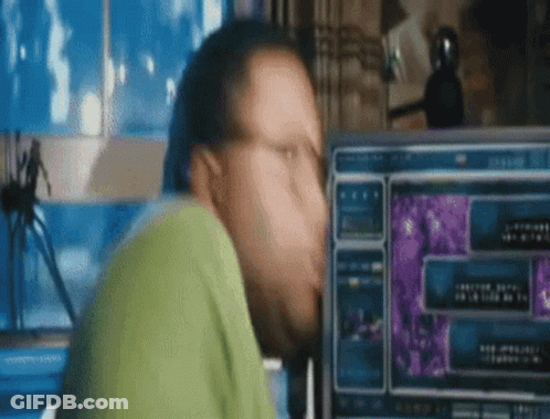 A Man Is Sitting In Front Of A Computer Screen . GIF