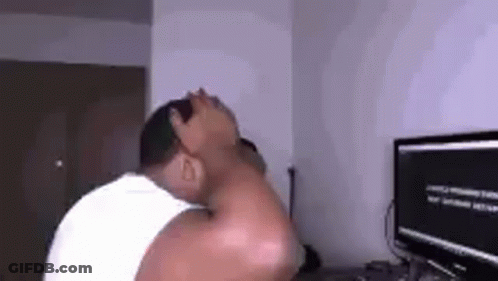 A Man Is Sitting In Front Of A Computer Screen . GIF