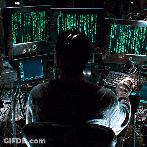 A Man Is Sitting In Front Of A Computer Screen That Says " Matrix " On It GIF