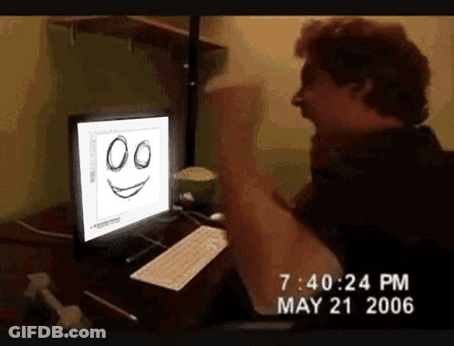 A Man Is Sitting In Front Of A Computer With A Smiley Face On It GIF