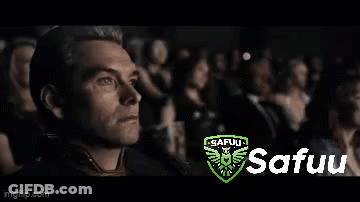 A Man Is Sitting In Front Of A Crowd Watching A Movie . GIF