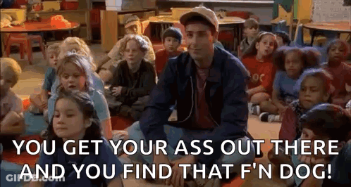 A Man Is Sitting In Front Of A Group Of Children In A Classroom And Talking To Them . GIF