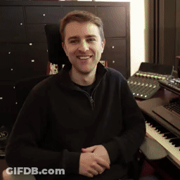 A Man Is Sitting In Front Of A Keyboard And Smiling GIF