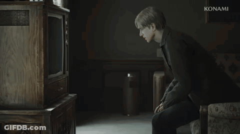 A Man Is Sitting In Front Of A Konami Television In A Dark Room GIF