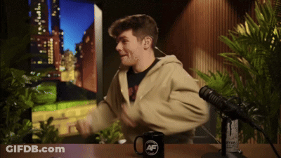 A Man Is Sitting In Front Of A Microphone And A Mug That Says Af On It GIF