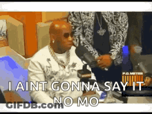 A Man Is Sitting In Front Of A Microphone And Saying I Ain T Gonna Say It No Mo . GIF