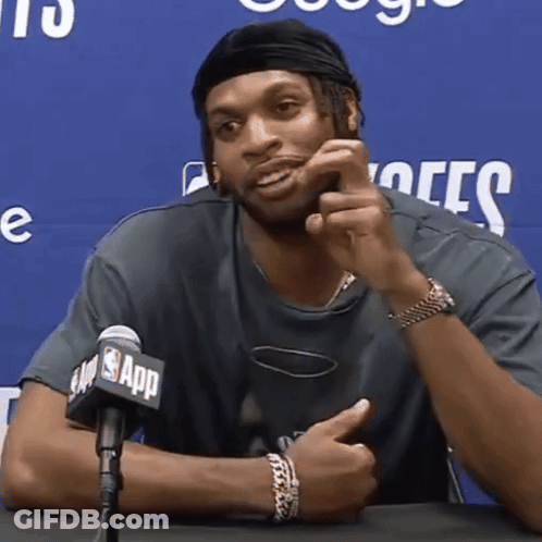 A Man Is Sitting In Front Of A Microphone That Says Nba App GIF