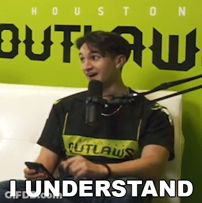 A Man Is Sitting In Front Of A Microphone While Holding A Cell Phone And Saying `` I Understand '' . GIF