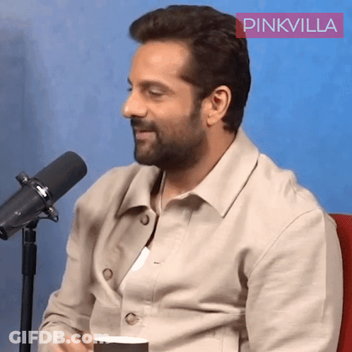 A Man Is Sitting In Front Of A Microphone With A Pinkvilla Logo In The Corner GIF
