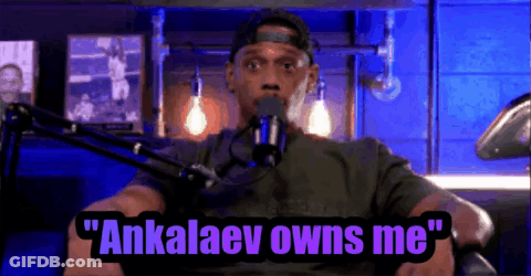 A Man Is Sitting In Front Of A Microphone With The Words " Ankalaev Owns Me " Above Him GIF