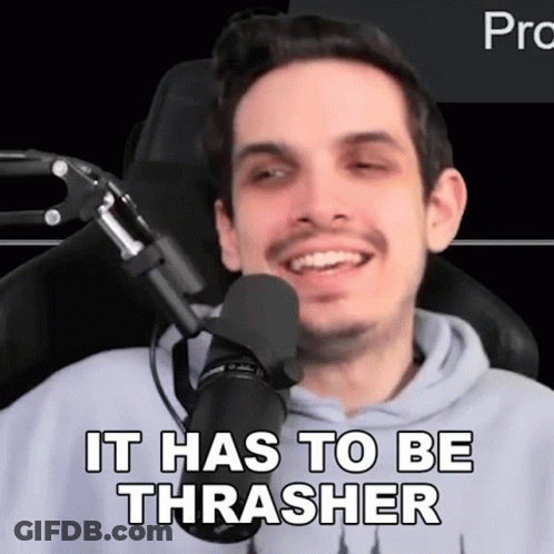 A Man Is Sitting In Front Of A Microphone With The Words It Has To Be Thrasher Written On His Face . GIF