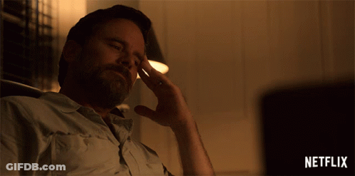 A Man Is Sitting In Front Of A Netflix Sign GIF