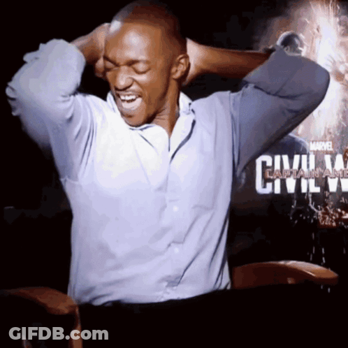 A Man Is Sitting In Front Of A Poster For Civil War GIF