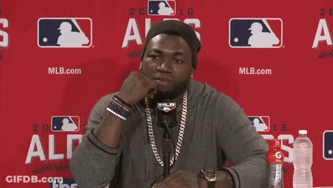 A Man Is Sitting In Front Of A Red Wall And Saying I 'M Ready GIF