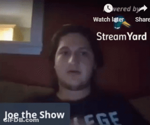 A Man Is Sitting In Front Of A Screen That Says " Joe The Show " GIF