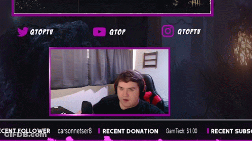 A Man Is Sitting In Front Of A Screen That Says Qtoptv On It GIF