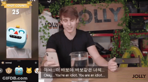 A Man Is Sitting In Front Of A Sign That Has The Word Jolly On It GIF