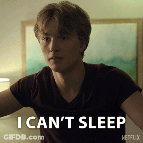 A Man Is Sitting In Front Of A Sign That Says I Can T Sleep GIF