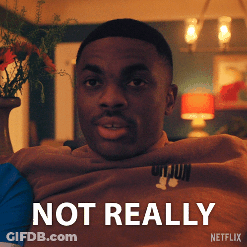 A Man Is Sitting In Front Of A Sign That Says Netflix GIF