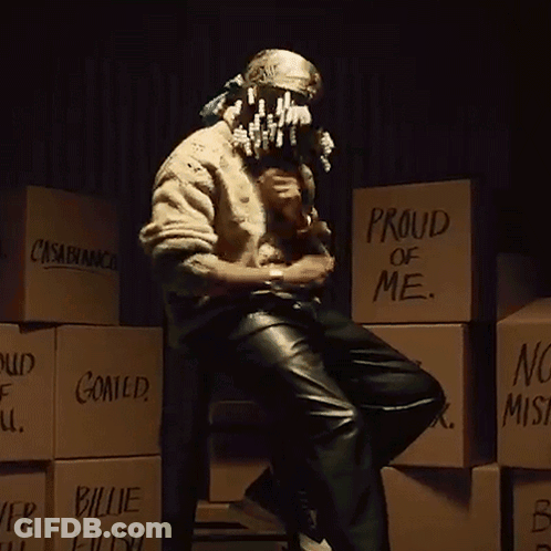 A Man Is Sitting In Front Of A Stack Of Boxes That Say Proud Of Me GIF