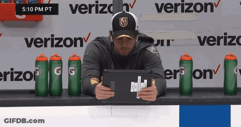 A Man Is Sitting In Front Of A Verizon Sign GIF