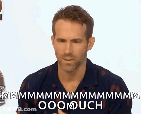 A Man Is Sitting In Front Of A White Wall And Making A Funny Face While Talking To Someone . GIF