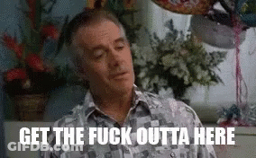 A Man Is Sitting In Front Of A Window With Balloons And Flowers In A Room . GIF