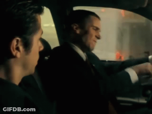 A Man Is Sitting In The Back Seat Of A Car . GIF