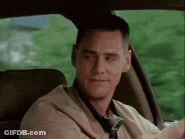 A Man Is Sitting In The Back Seat Of A Car Looking At The Camera . GIF