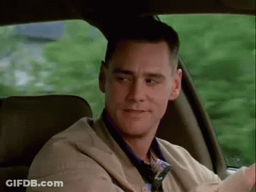 A Man Is Sitting In The Back Seat Of A Car Looking Out The Window . GIF