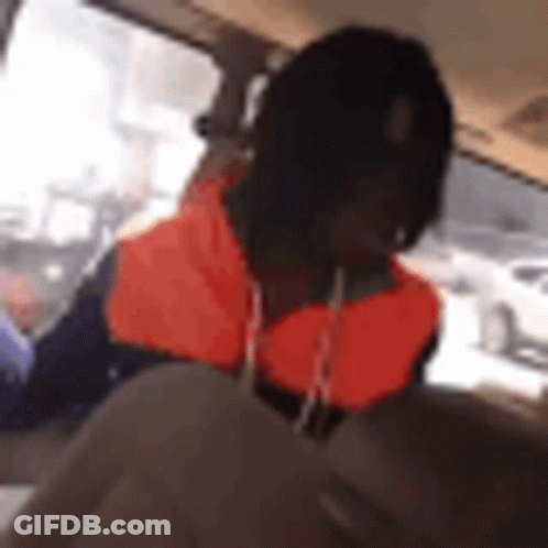 A Man Is Sitting In The Back Seat Of A Car . GIF