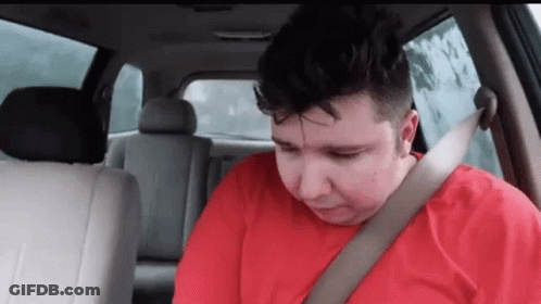 A Man Is Sitting In The Back Seat Of A Car Wearing A Seat Belt . GIF