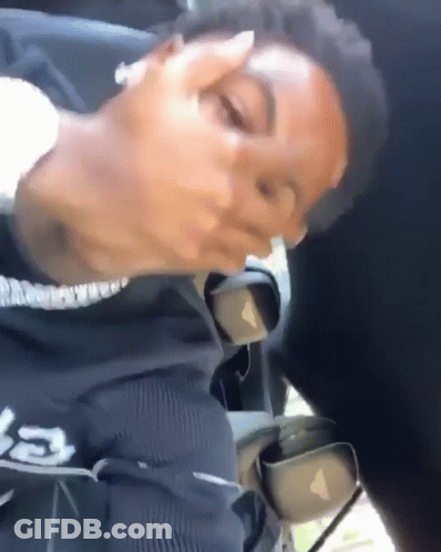 A Man Is Sitting In The Back Seat Of A Car With His Eyes Closed And His Mouth Open . GIF