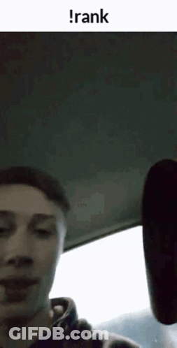 A Man Is Sitting In The Back Seat Of A Car With The Word Rank On The Bottom . GIF