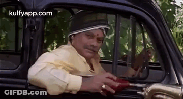 A Man Is Sitting In The Driver 'S Seat Of A Car And Holding An Umbrella . GIF