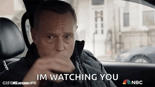 A Man Is Sitting In The Driver 'S Seat Of A Car And Saying `` Im Watching You '' . GIF